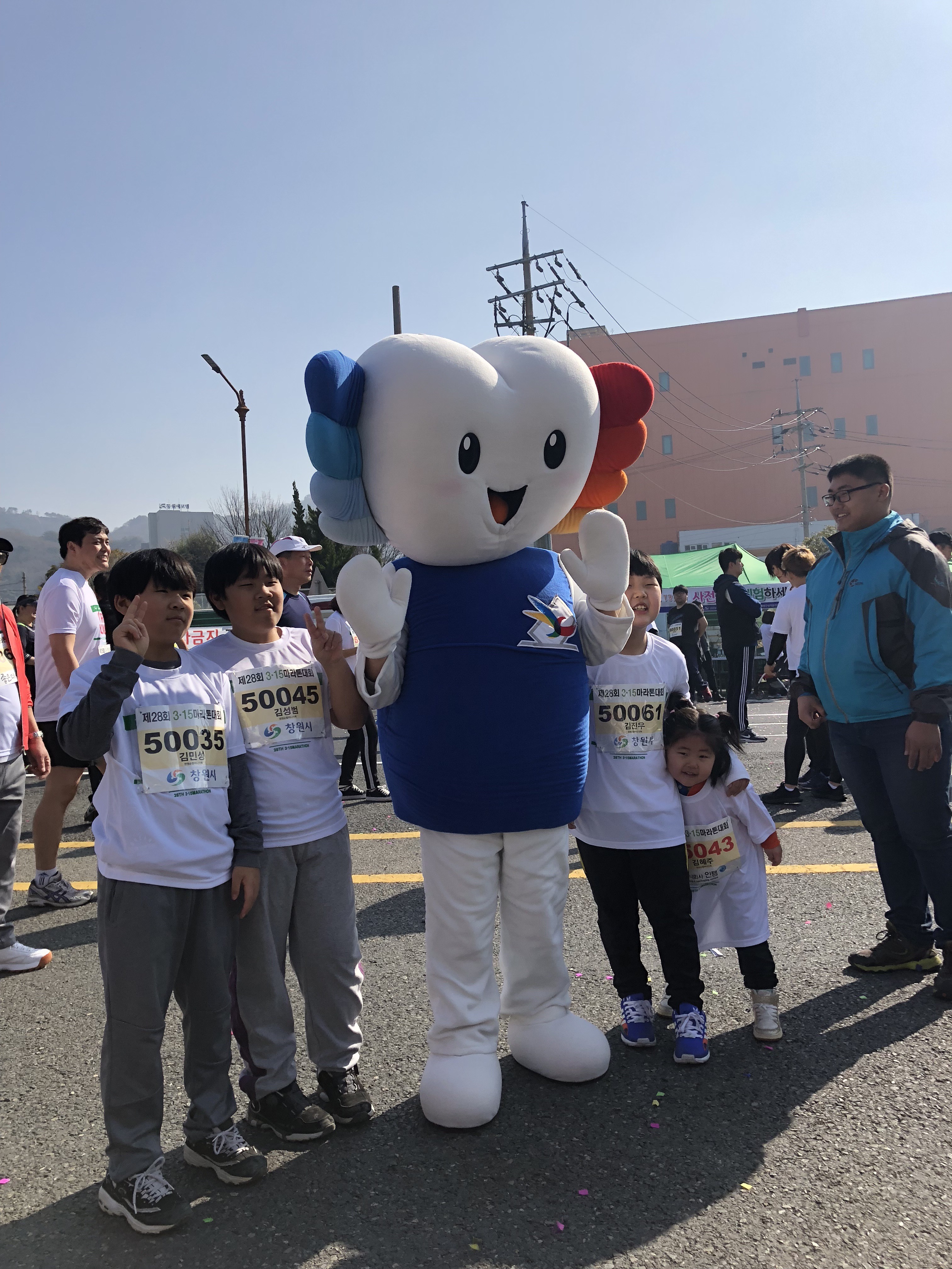 3.15마라톤에 참가한 미래유권자 어린이들이 위원회 홍보캐릭터 '알리'와 함께 기념사진을 찍고 있다.