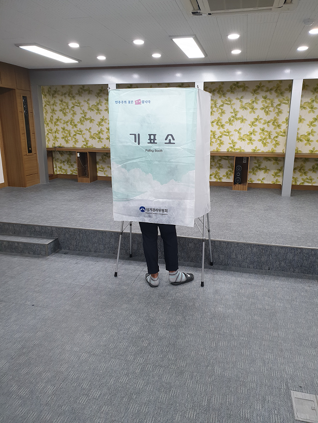 학생이 기표대에 들어가 투표하는 모습
