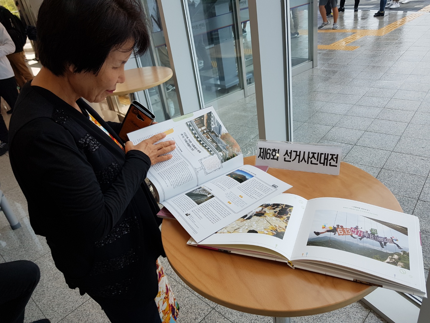  2018년10월5일 밀양아리랑아트센터에서 관람객이 선거사진대전 수상작품집 및 SNS매거진을 보고있는 모습입니다.